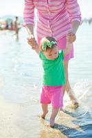 mamá y bebé en la playa se divierten foto