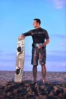 Portrait of a young  kitsurf  man at beach on sunset photo
