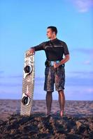 retrato, de, un, joven, kitsurf, hombre, en, playa, en, ocaso foto