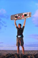 Portrait of a young  kitsurf  man at beach on sunset photo