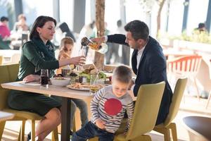 Young parents enjoying lunch time with their children photo