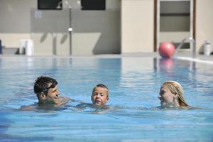 happy young family have fun on swimming pool photo