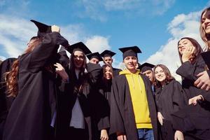 grupo de diversos estudiantes graduados internacionales celebrando foto