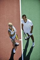 happy young couple play tennis game outdoor photo