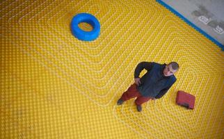 workers installing underfloor heating system photo