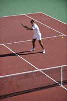 mujer joven jugar al tenis al aire libre foto