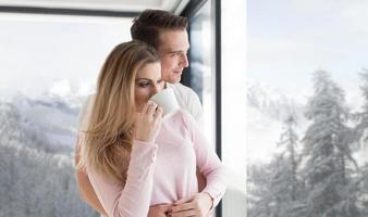 young couple enjoying morning coffee by the window photo