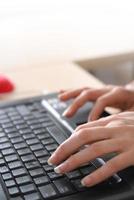 woman hands typing on laptop keyboard photo