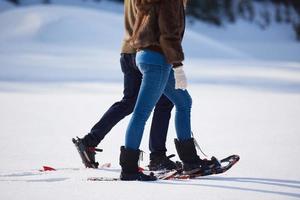 pareja divirtiéndose y caminando con raquetas de nieve foto