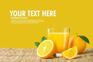 Glass of fresh orange juice on a rattan basket, Fresh fruits Orange juice in glass with group on yellow background with copy Space for your photo