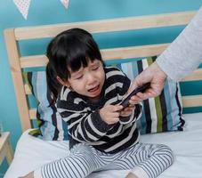 su madre sostiene el teléfono con un niño llorando. no use el teléfono inteligente foto