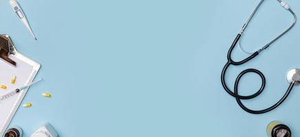 Flatlay creativo de equipo médico médico mesa azul con estetoscopio, documentos médicos, termómetro, jeringa y pastillas, concepto de atención médica, vista superior con espacio de copia para su texto foto