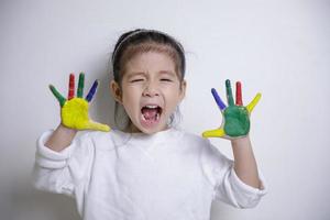 la creatividad de los niños, las manos de las niñas asiáticas pintadas con pinturas de colores sobre fondo blanco, el concepto educativo para la escuela foto