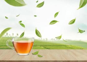 taza caliente de té en la mesa de madera con hojas de té verde voladoras en el aire en las plantaciones de té, productos saludables por concepto de ingredientes naturales orgánicos, espacio vacío en el estudio foto