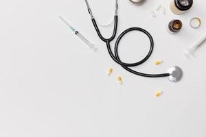 Creative flatlay of doctor medical equipment white table with stethoscope, medical documents, thermometer, syringe and pills, Health care concept, Top view with copy space, Isolated on white photo