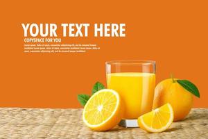 Glass of fresh orange juice on a rattan basket, Fresh fruits Orange juice in glass with group on orange color background with copy Space for your text. photo