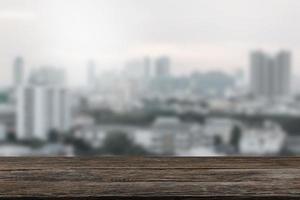 mesa de madera vacía con vistas a la ciudad o escritorio de madera con paisaje urbano con fondo borroso, espacio para copiar el texto foto