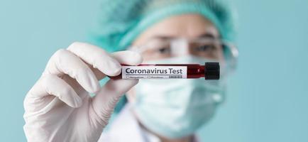 Doctor wearing respirator mask for stop Coronavirus Outbreak COVID-19 and holding testing patients blood samples for Corona Virus from Wuhan China in Laboratory, Empty space isolated on long banner photo