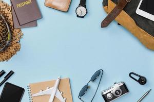 Top view mockup of Traveler's accessories with passport, books of travel plan, wallet, camera, hat, backpack and airplane toy isolated colorful blue background with empty space,Tropical travel concept photo