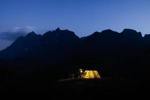 Glowing yellow tent in the mountains with cloud in natural park, Tourism concept photo