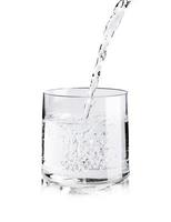 verter agua pura fresca en un vaso aislado sobre fondo blanco, concepto de hidratación de salud y belleza foto
