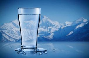 Mineral water in a glass with water drops in the iceberg background, Healthcare and beauty hydration concept photo