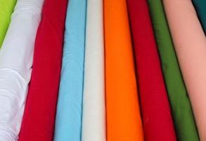 Detailed close up view on samples of cloth and fabrics in different colors found at a fabrics market photo
