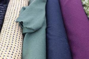 Detailed close up view on samples of cloth and fabrics in different colors found at a fabrics market photo
