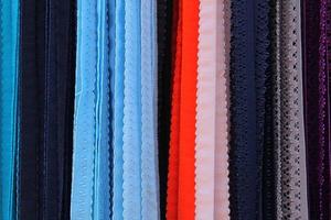 Detailed close up view on samples of cloth and fabrics in different colors found at a fabrics market photo