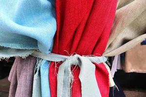 Detailed close up view on samples of cloth and fabrics in different colors found at a fabrics market photo