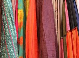 Detailed close up view on samples of cloth and fabrics in different colors found at a fabrics market photo