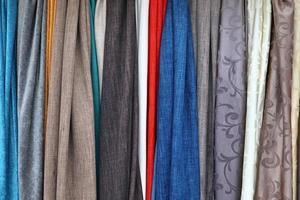 Detailed close up view on samples of cloth and fabrics in different colors found at a fabrics market photo