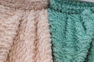 Detailed close up view on samples of cloth and fabrics in different colors found at a fabrics market photo