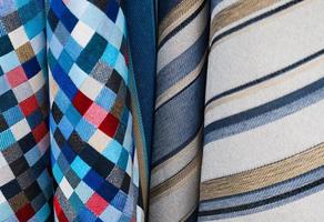 Detailed close up view on samples of cloth and fabrics in different colors found at a fabrics market photo