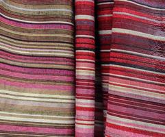 Detailed close up view on samples of cloth and fabrics in different colors found at a fabrics market photo