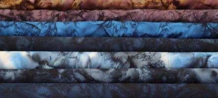 Detailed close up view on samples of cloth and fabrics in different colors found at a fabrics market photo