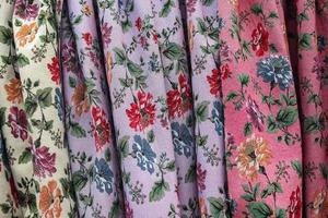 Detailed close up view on samples of cloth and fabrics in different colors found at a fabrics market photo