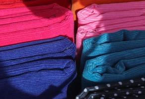 Detailed close up view on samples of cloth and fabrics in different colors found at a fabrics market photo