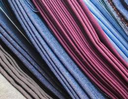Detailed close up view on samples of cloth and fabrics in different colors found at a fabrics market photo
