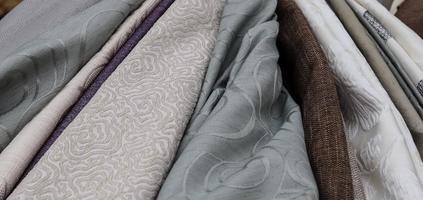Detailed close up view on samples of cloth and fabrics in different colors found at a fabrics market photo