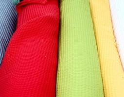 Detailed close up view on samples of cloth and fabrics in different colors found at a fabrics market photo