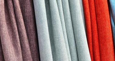 Detailed close up view on samples of cloth and fabrics in different colors found at a fabrics market photo