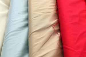 Detailed close up view on samples of cloth and fabrics in different colors found at a fabrics market photo