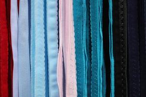 Detailed close up view on samples of cloth and fabrics in different colors found at a fabrics market photo