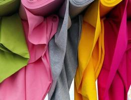 Detailed close up view on samples of cloth and fabrics in different colors found at a fabrics market photo