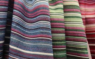 Detailed close up view on samples of cloth and fabrics in different colors found at a fabrics market photo