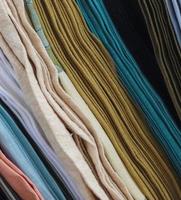 Detailed close up view on samples of cloth and fabrics in different colors found at a fabrics market photo