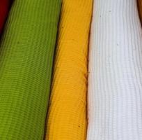 Detailed close up view on samples of cloth and fabrics in different colors found at a fabrics market photo