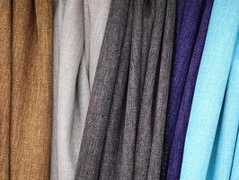 Detailed close up view on samples of cloth and fabrics in different colors found at a fabrics market photo