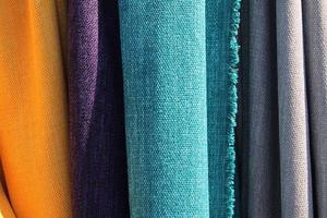 Detailed close up view on samples of cloth and fabrics in different colors found at a fabrics market photo